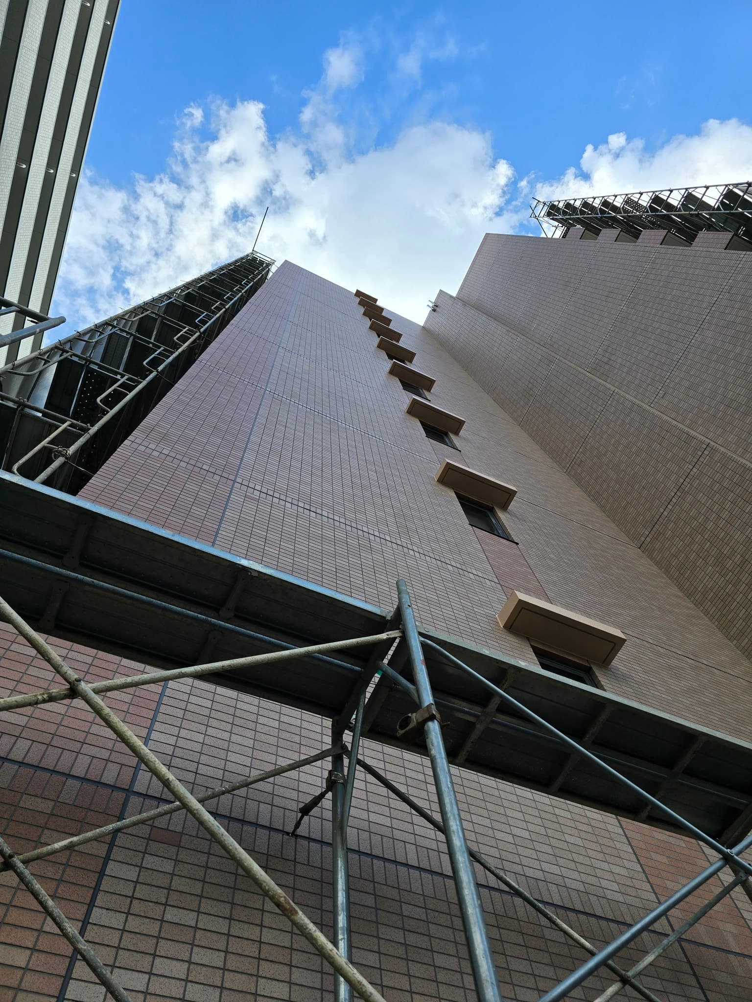 足場が組まれた建物を見上げた施工現場